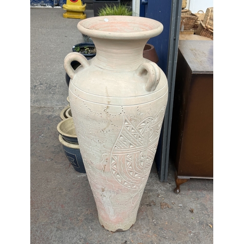 120 - A large painted terracotta floor standing three handled amphora vase - approx. 111cm high