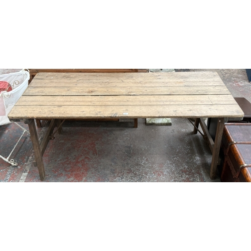 130 - An early 20th century pine folding trestle table - approx. 72cm high x 85cm wide x 182cm long