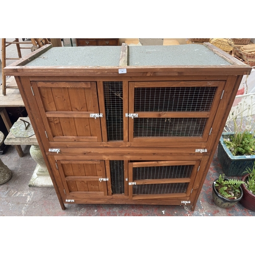 134 - A wooden two-tier rabbit hutch - approx. 131cm high x 122cm wide x 65cm deep