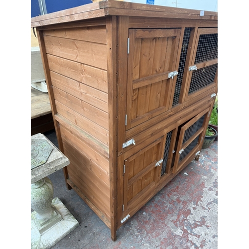 134 - A wooden two-tier rabbit hutch - approx. 131cm high x 122cm wide x 65cm deep