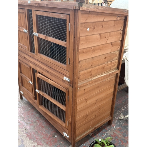 134 - A wooden two-tier rabbit hutch - approx. 131cm high x 122cm wide x 65cm deep