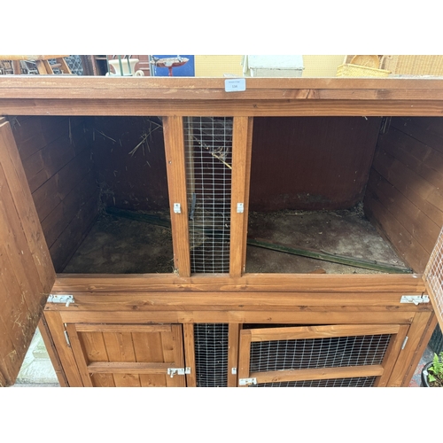 134 - A wooden two-tier rabbit hutch - approx. 131cm high x 122cm wide x 65cm deep