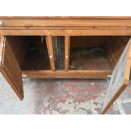 134 - A wooden two-tier rabbit hutch - approx. 131cm high x 122cm wide x 65cm deep