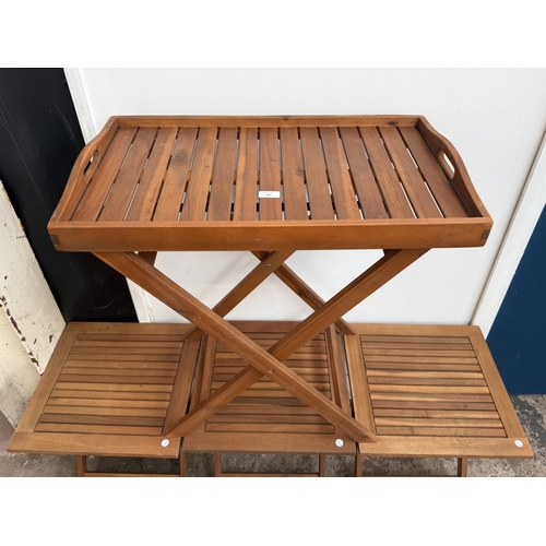 140 - Four stained teak folding garden side tables, three approx. 45cm high x 45cm square and one with rem... 