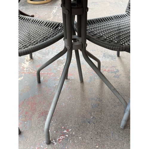 160 - A grey metal three-piece patio set comprising circular glass-top table and two plastic wicker effect... 