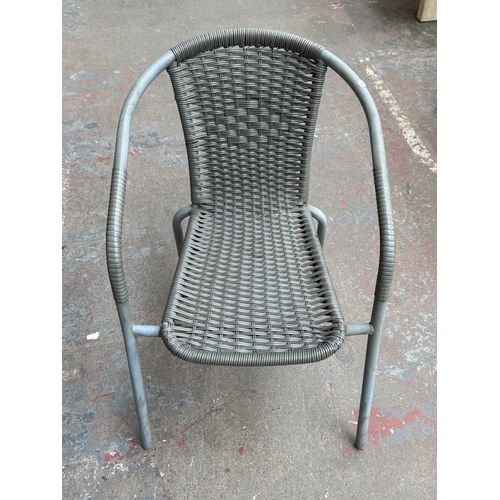 160 - A grey metal three-piece patio set comprising circular glass-top table and two plastic wicker effect... 