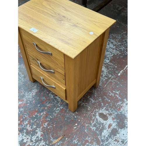 168 - A modern oak bedside chest of drawers - approx. 57cm high x 50cm wide x 35cm deep