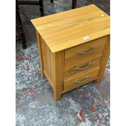 168 - A modern oak bedside chest of drawers - approx. 57cm high x 50cm wide x 35cm deep