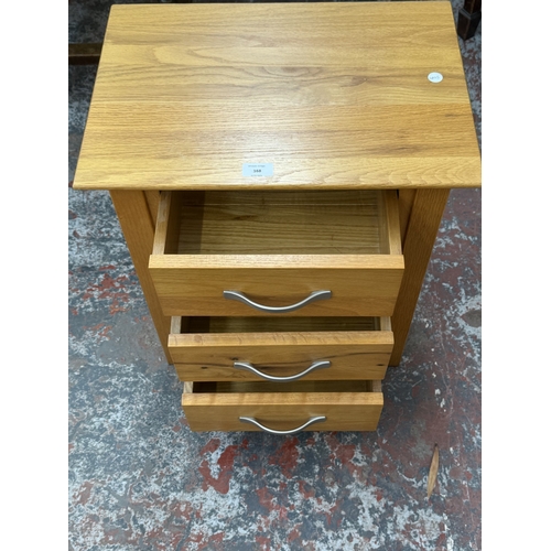 168 - A modern oak bedside chest of drawers - approx. 57cm high x 50cm wide x 35cm deep