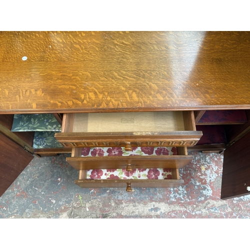 178 - A mid 20th century Austinsuite carved oak four piece bedroom suite comprising two double wardrobes, ... 