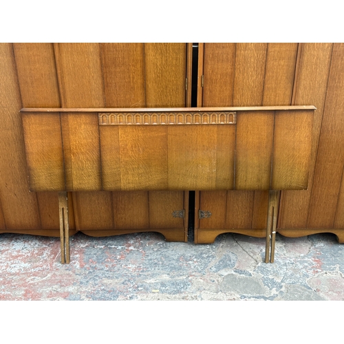 178 - A mid 20th century Austinsuite carved oak four piece bedroom suite comprising two double wardrobes, ... 