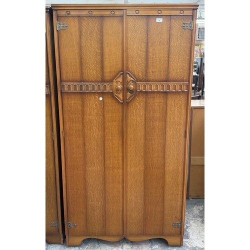 178 - A mid 20th century Austinsuite carved oak four piece bedroom suite comprising two double wardrobes, ... 