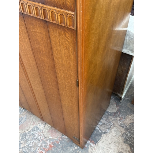 178 - A mid 20th century Austinsuite carved oak four piece bedroom suite comprising two double wardrobes, ... 
