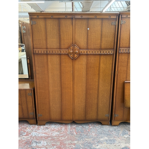 178 - A mid 20th century Austinsuite carved oak four piece bedroom suite comprising two double wardrobes, ... 
