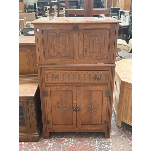 96 - A Jaycee carved oak linenfold cocktail cabinet - approx. 124cm high x 75cm wide x 43cm deep
