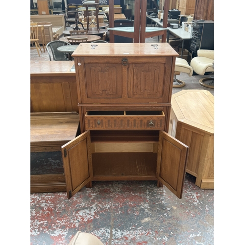 96 - A Jaycee carved oak linenfold cocktail cabinet - approx. 124cm high x 75cm wide x 43cm deep