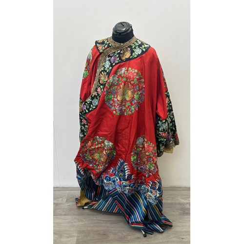 An antique Chinese Qing dynasty red silk woman's informal robe with embroidered pomegranate and peony roundels