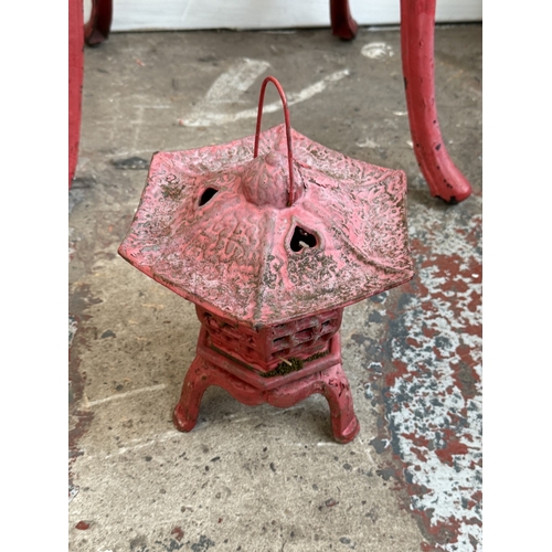 209A - Two red painted cast iron garden items, one Oriental style pagoda lantern - approx. 27cm high and on... 