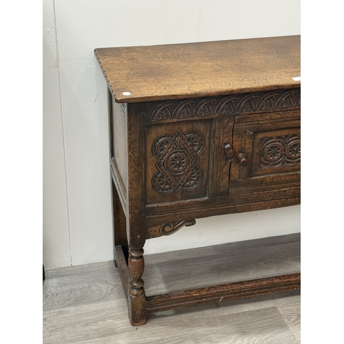 10 - An early/mid 20th century Jacobean style carved oak side cabinet, bearing 'Hunters Furnishers Derby'... 