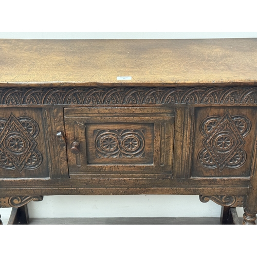 10 - An early/mid 20th century Jacobean style carved oak side cabinet, bearing 'Hunters Furnishers Derby'... 