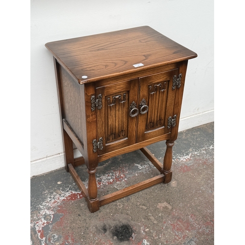 11 - A mid/late 20th century carved oak linenfold two door cabinet - approx. 72cm high x 51cm wide x 38cm... 
