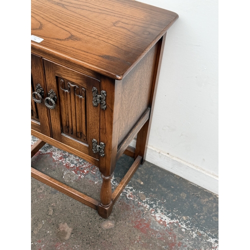 11 - A mid/late 20th century carved oak linenfold two door cabinet - approx. 72cm high x 51cm wide x 38cm... 