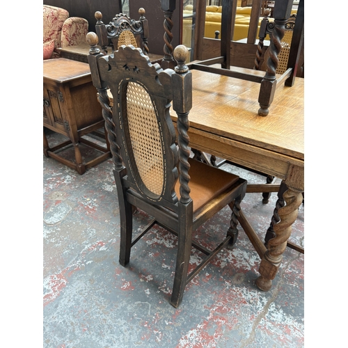 12 - An early 20th century oak draw leaf barley twist dining table and four oak and cane back barley twis... 