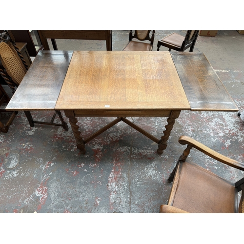 12 - An early 20th century oak draw leaf barley twist dining table and four oak and cane back barley twis... 