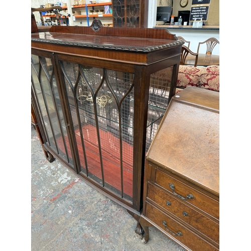 15 - An early 20th century Georgian style carved mahogany bow fronted display cabinet on ball and claw su... 