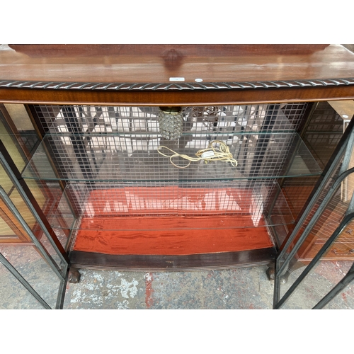 15 - An early 20th century Georgian style carved mahogany bow fronted display cabinet on ball and claw su... 