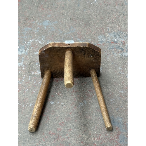 18 - A 19th century elm tripod milking stool - approx. 35cm high x 29cm wide x 19cm deep