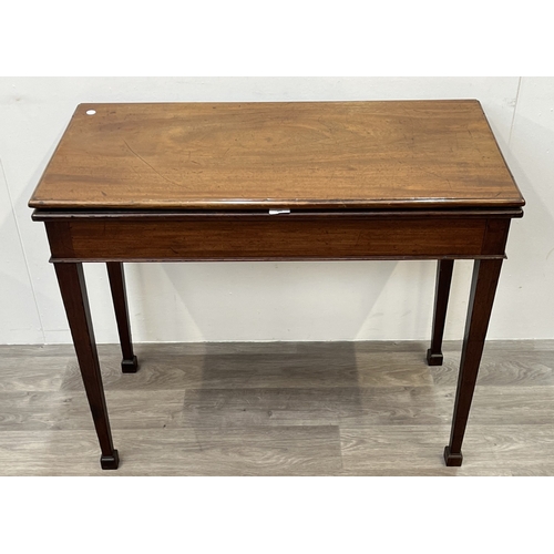 A George III mahogany fold over card table with green baize lined top ...