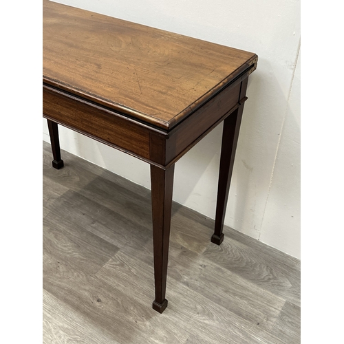 A George III mahogany fold over card table with green baize lined top ...