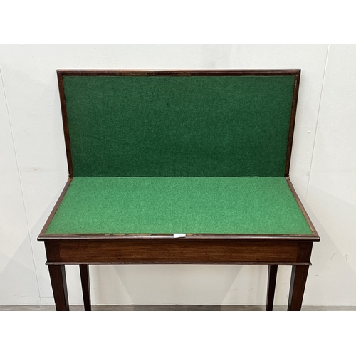 A George III mahogany fold over card table with green baize lined top ...