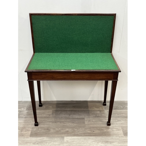 A George III mahogany fold over card table with green baize lined top ...