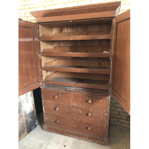 105 - A Victorian stained pine linen press, upper cupboard housing four slides above a chest of four drawe... 