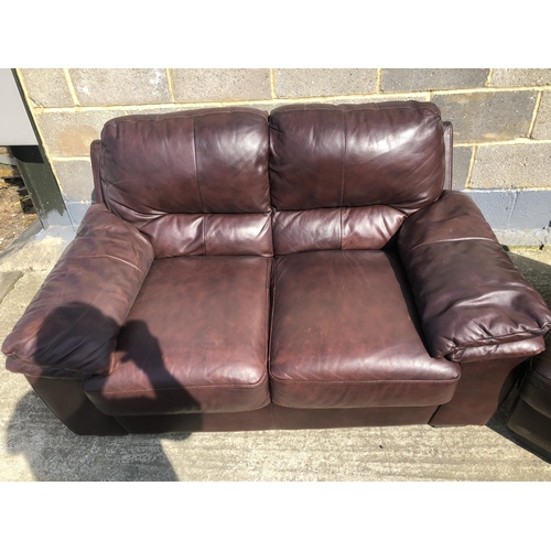 181 - A modern brown leather two seater sofa together with a brown leather footstool