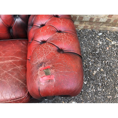 30 - A red leather chesterfield sofa, three cushion seat with buttoned back