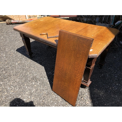 89 - An Oak wind out dining table with extension leaf and winding handle 195cm x 61cm x 72cm