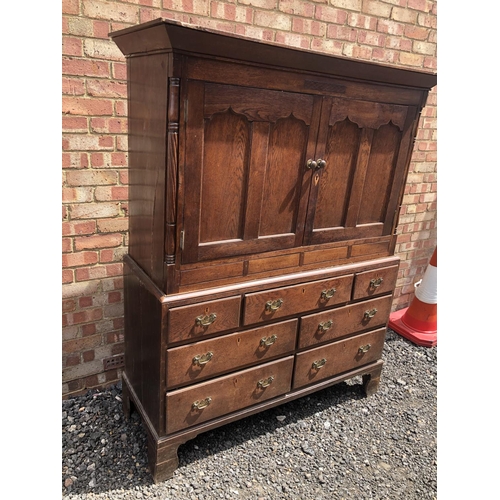 107 - A Welsh period oak house keepers cupboard. Two door top with a single shelf, over seven drawer base.... 