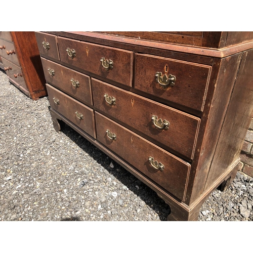 107 - A Welsh period oak house keepers cupboard. Two door top with a single shelf, over seven drawer base.... 