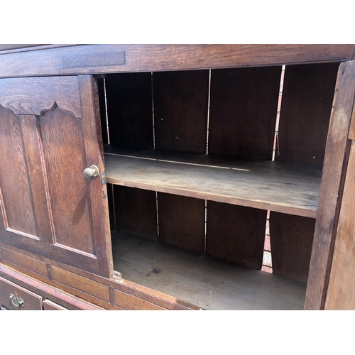 107 - A Welsh period oak house keepers cupboard. Two door top with a single shelf, over seven drawer base.... 