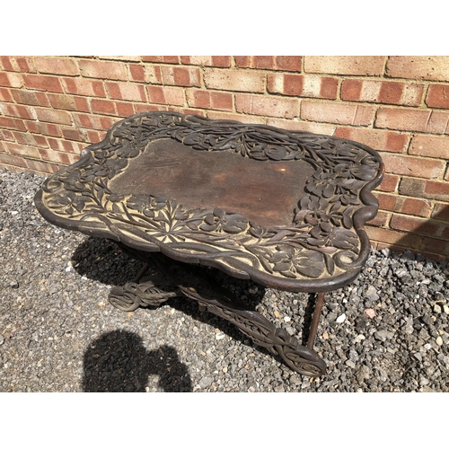 117 - A carved African style tray table on folding x frame base