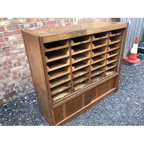 13 - A early 20th century haberdashery shop cabinet housing 28 sliding compartments 153x52x138