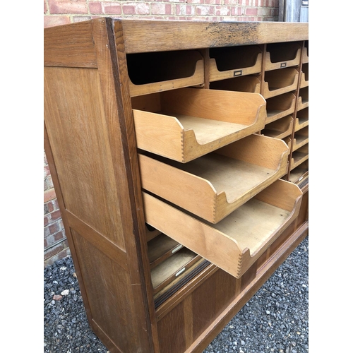 13 - A early 20th century haberdashery shop cabinet housing 28 sliding compartments 153x52x138