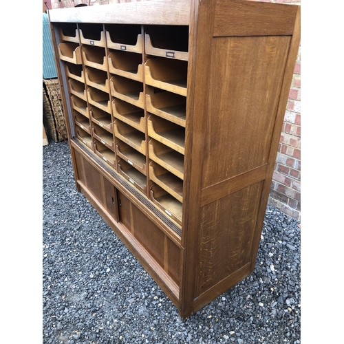 13 - A early 20th century haberdashery shop cabinet housing 28 sliding compartments 153x52x138