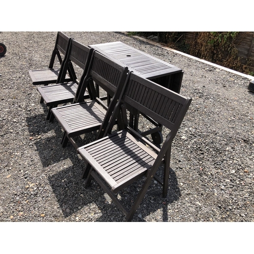 174 - A hardwood garden table and four folding chairs