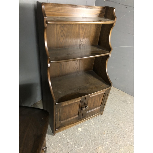 196 - An Ercol waterfall front bookcase together with a matching single drawer occasional table