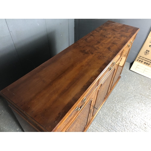 204 - A reproduction yew wood sideboard, three drawers over three cupboards 153x40x87