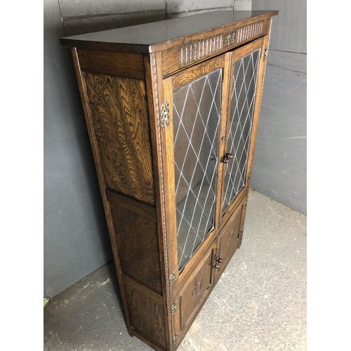 227 - A oak leaded cabinet with two adjustable shelves